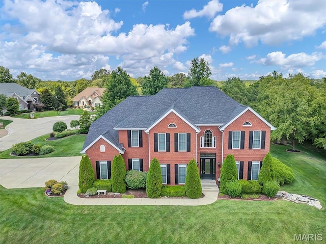 1011 Hawks Landing Dr, Lake St Louis, MO 63367 - colonial house featuring brick siding, a front lawn, driveway, and a shingled roof
