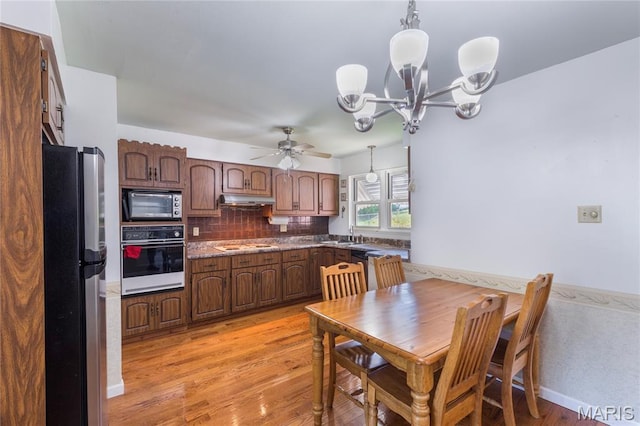 7373 Marwinette Ave, Saint Louis, MO 63116 - kitchen featuring white appliances, under cabinet range hood, light wood-type flooring, ceiling fan, and backsplash