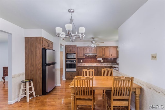 7373 Marwinette Ave, Saint Louis, MO 63116 - dining area featuring a chandelier, a ceiling fan, and light wood-style flooring
