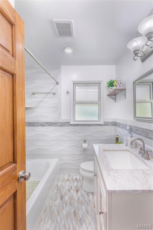 7373 Marwinette Ave, Saint Louis, MO 63116 - bathroom with tile walls, vanity, tub / shower combination, and tile patterned flooring
