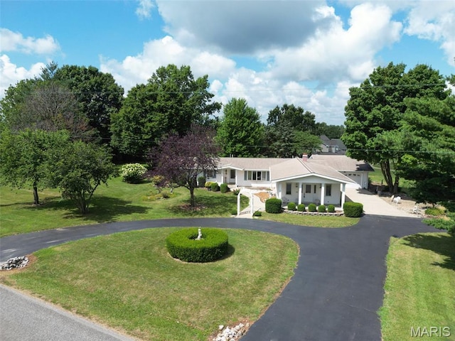 613 N W St, Raymond, IL 62560 - view of front facade with curved driveway, covered porch, a front yard, and an attached garage