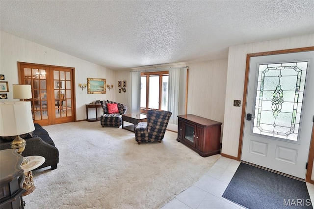 613 N W St, Raymond, IL 62560 - entrance foyer with french doors, vaulted ceiling, a textured ceiling, wood walls, and light tile patterned floors