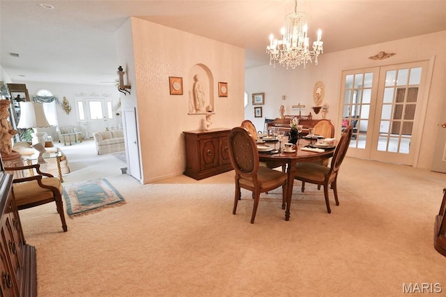 613 N W St, Raymond, IL 62560 - dining area with light carpet, a chandelier, a ceiling fan, and french doors