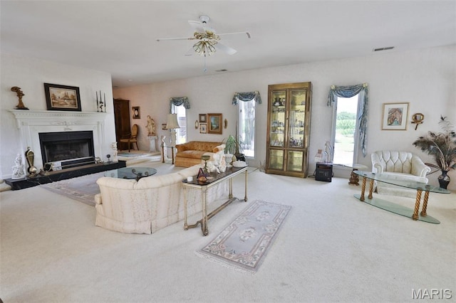613 N W St, Raymond, IL 62560 - carpeted living room with a ceiling fan and a fireplace with raised hearth