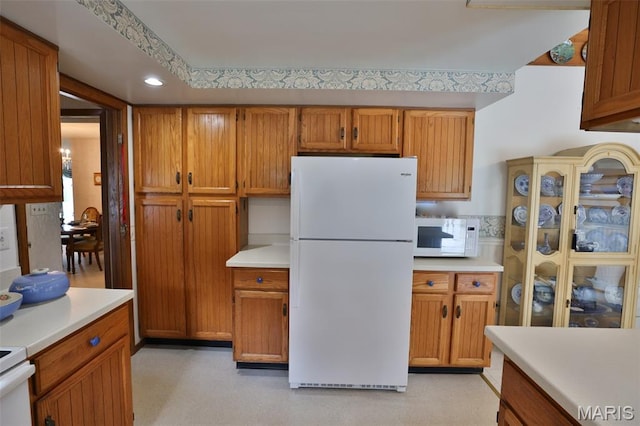 613 N W St, Raymond, IL 62560 - kitchen featuring white appliances, light countertops, and brown cabinetry