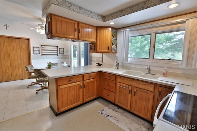 613 N W St, Raymond, IL 62560 - kitchen with white electric range oven, light countertops, ceiling fan, a peninsula, and brown cabinets