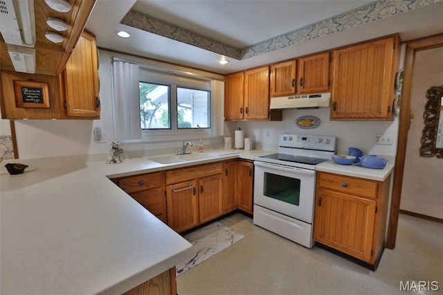 613 N W St, Raymond, IL 62560 - kitchen with electric stove, under cabinet range hood, light countertops, brown cabinetry, and recessed lighting
