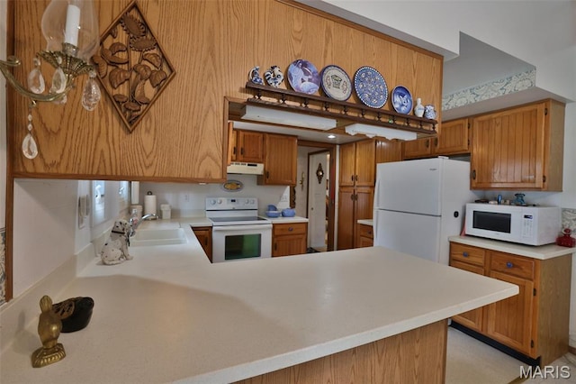 613 N W St, Raymond, IL 62560 - kitchen featuring white appliances, under cabinet range hood, light countertops, a peninsula, and brown cabinets