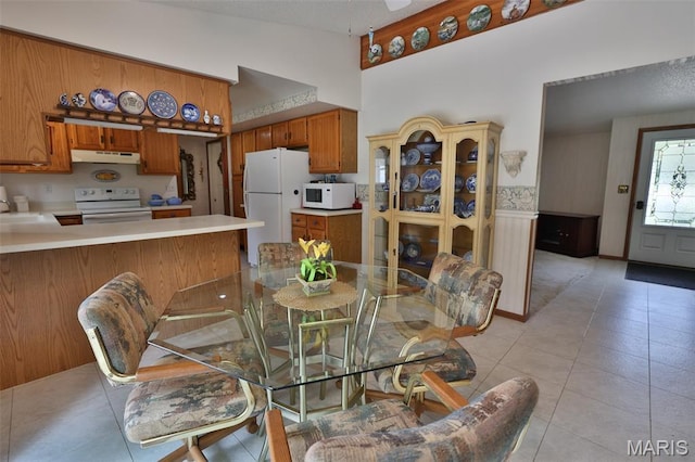 613 N W St, Raymond, IL 62560 - dining space with light tile patterned floors, high vaulted ceiling, and wainscoting