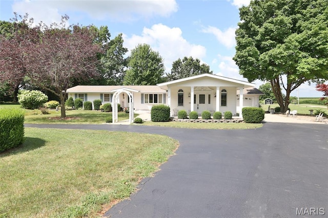 613 N W St, Raymond, IL 62560 - view of front of property with driveway, a front lawn, a garage, and covered porch