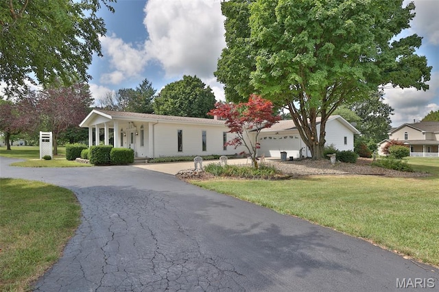 613 N W St, Raymond, IL 62560 - view of front facade with asphalt driveway, a front lawn, covered porch, and an attached garage