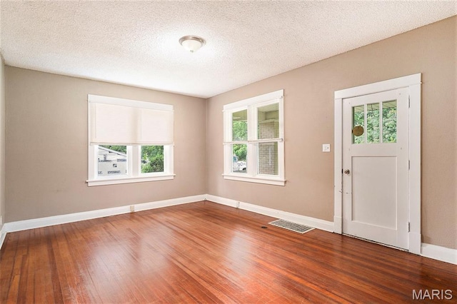 11714 Larimore Rd, Saint Louis, MO 63138 - foyer featuring healthy amount of natural light, wood finished floors, and a textured ceiling