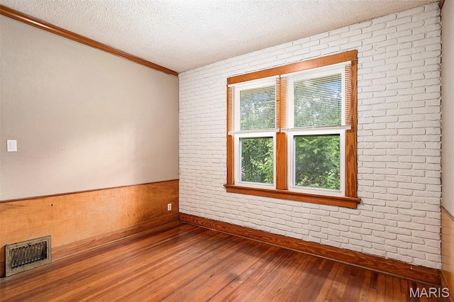 11714 Larimore Rd, Saint Louis, MO 63138 - empty room with hardwood / wood-style floors, a textured ceiling, and ornamental molding