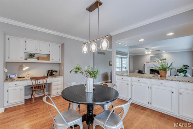 13153 Barrett Meadows Dr, Ballwin, MO 63021 - dining room with light wood finished floors, built in desk, ornamental molding, ceiling fan, and recessed lighting