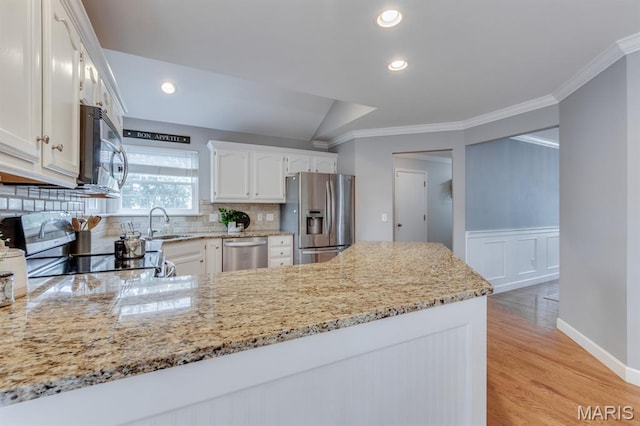 13153 Barrett Meadows Dr, Ballwin, MO 63021 - kitchen with appliances with stainless steel finishes, a peninsula, crown molding, white cabinets, and decorative backsplash