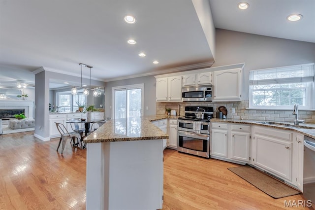 13153 Barrett Meadows Dr, Ballwin, MO 63021 - kitchen featuring stainless steel appliances, a peninsula, white cabinets, light stone countertops, and decorative backsplash