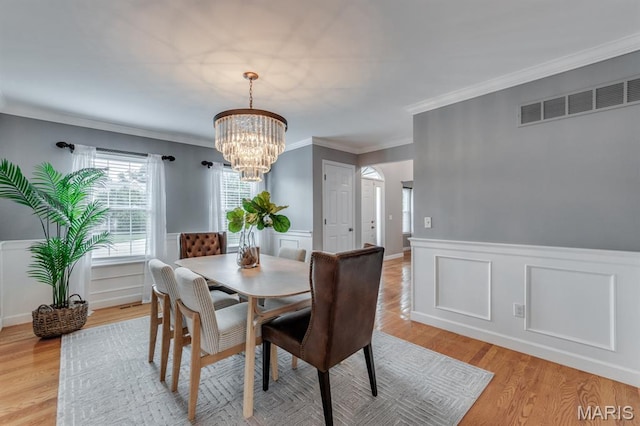 13153 Barrett Meadows Dr, Ballwin, MO 63021 - dining room featuring a chandelier, light wood-type flooring, a wainscoted wall, a decorative wall, and ornamental molding