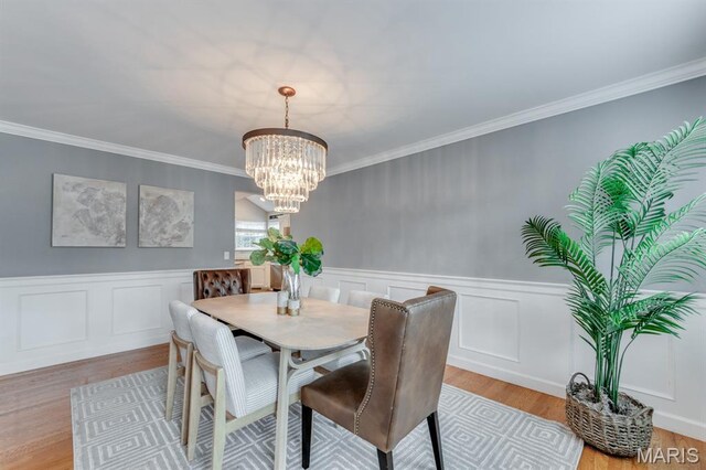 13153 Barrett Meadows Dr, Ballwin, MO 63021 - dining room featuring a chandelier, light wood-style floors, ornamental molding, and wainscoting