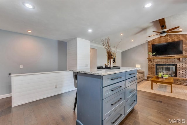 3534 Carriage Run Dr, Saint Charles, MO 63303 - kitchen with open floor plan, ceiling fan, gray cabinetry, dark wood finished floors, and a brick fireplace