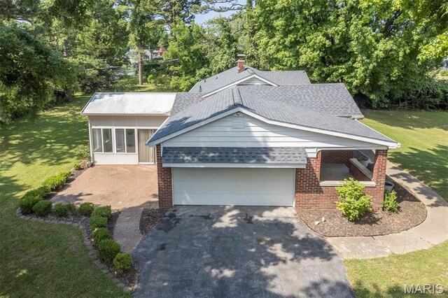 110 N 74th St, Belleville, IL 62223 - view of front facade featuring brick siding, driveway, a front lawn, a garage, and roof with shingles