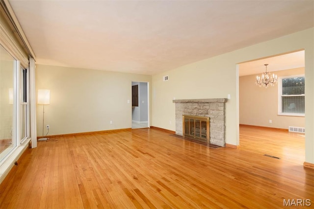 110 N 74th St, Belleville, IL 62223 - unfurnished living room with light wood-style floors, a chandelier, and a fireplace