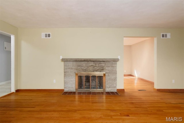 110 N 74th St, Belleville, IL 62223 - unfurnished living room with wood finished floors and a stone fireplace