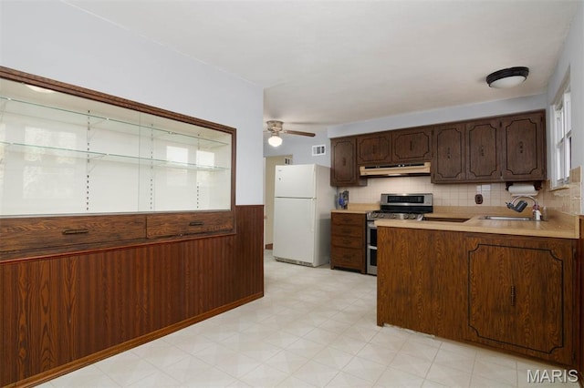 110 N 74th St, Belleville, IL 62223 - kitchen with freestanding refrigerator, under cabinet range hood, range with two ovens, light countertops, and a peninsula