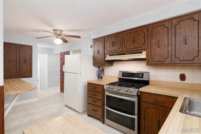 110 N 74th St, Belleville, IL 62223 - kitchen featuring under cabinet range hood, double oven range, freestanding refrigerator, tasteful backsplash, and ceiling fan