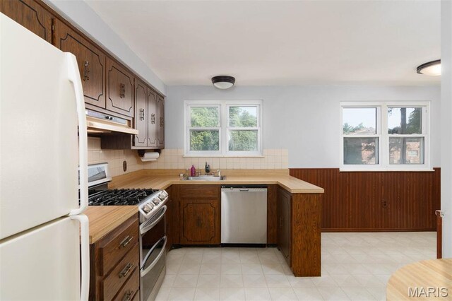 110 N 74th St, Belleville, IL 62223 - kitchen featuring stainless steel appliances, under cabinet range hood, light countertops, decorative backsplash, and a peninsula