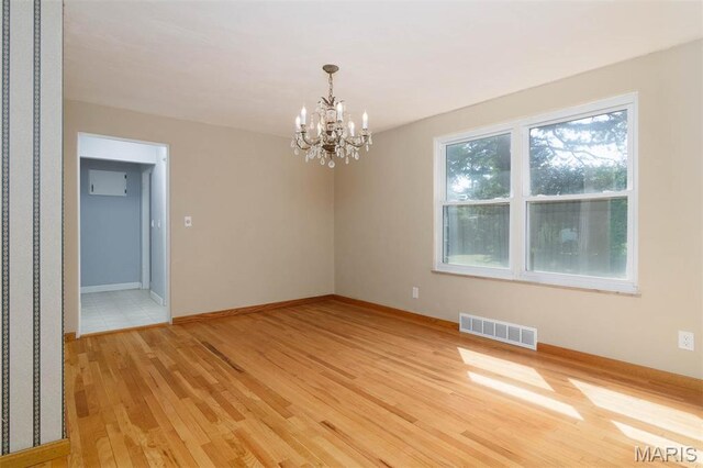 110 N 74th St, Belleville, IL 62223 - spare room with light wood-style flooring and a chandelier