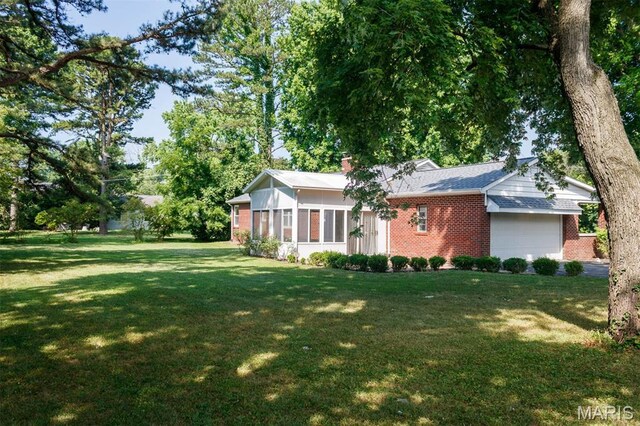 110 N 74th St, Belleville, IL 62223 - view of front facade with brick siding, an attached garage, a front yard, and a chimney