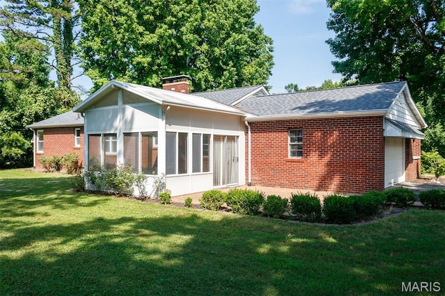 110 N 74th St, Belleville, IL 62223 - back of property with brick siding, a chimney, a sunroom, and a yard