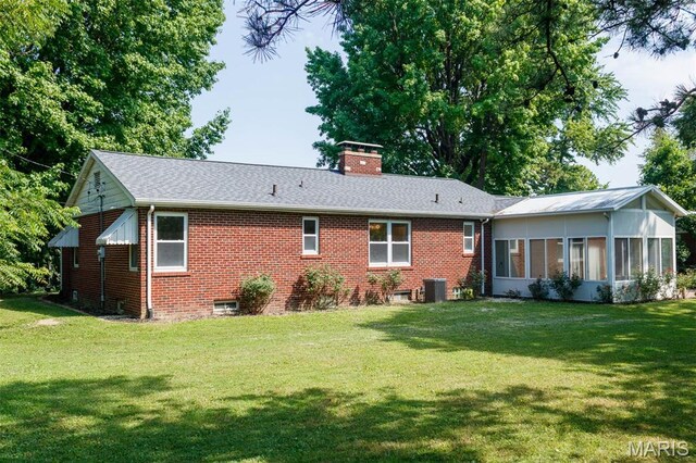 110 N 74th St, Belleville, IL 62223 - back of house featuring a chimney, a sunroom, a lawn, and brick siding