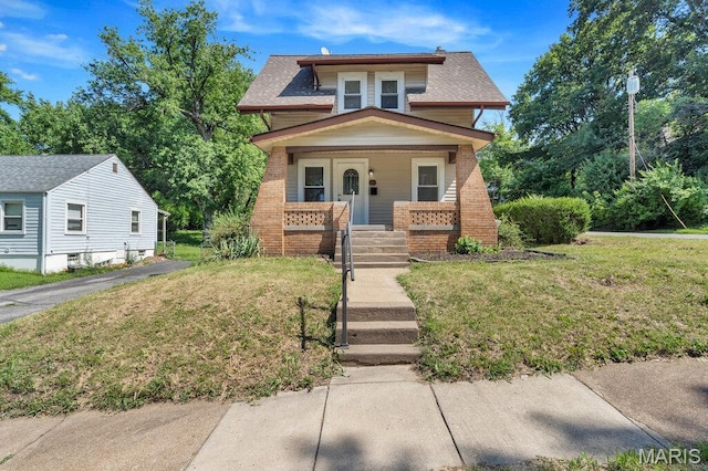 401 Estelle Ave, Ferguson, MO 63135 - view of front of home with covered porch, a front lawn, roof with shingles, and brick siding