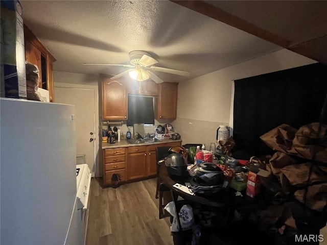 821 Center St, East Alton, IL 62024 - kitchen featuring freestanding refrigerator, ceiling fan, light wood-type flooring, light countertops, and brown cabinetry