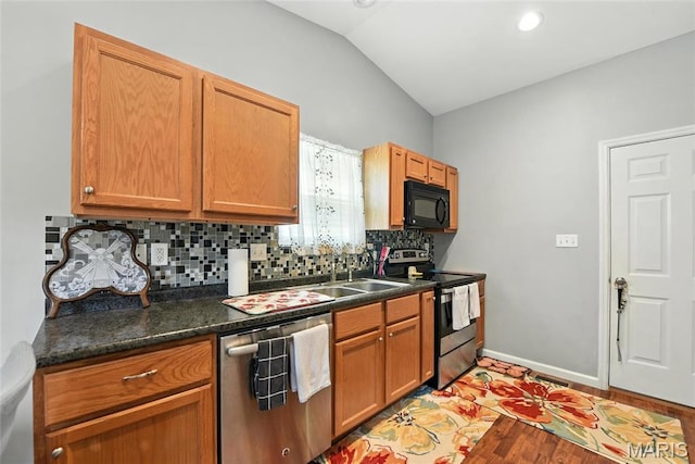 2364 Arkansas Dr, High Ridge, MO 63049 - kitchen featuring stainless steel appliances, lofted ceiling, tasteful backsplash, dark countertops, and light wood finished floors