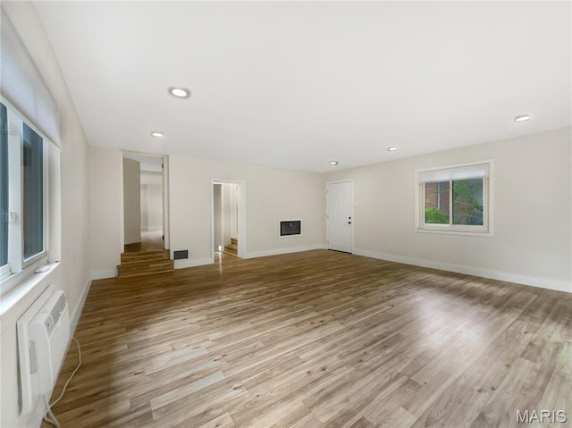 614 Conover Ln, Saint Louis, MO 63126 - unfurnished living room featuring light wood finished floors, recessed lighting, and an AC wall unit