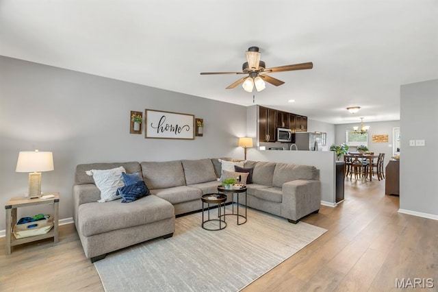 688 Rabbit Run Dr, Wentzville, MO 63385 - living area with light wood-type flooring, a ceiling fan, and a chandelier