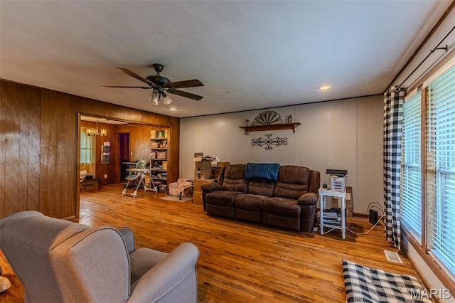 304 Warren St, Richland, MO 65556 - living room featuring wood finished floors, wood walls, plenty of natural light, and ceiling fan