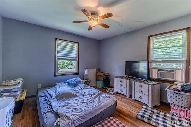 304 Warren St, Richland, MO 65556 - bedroom with multiple windows, cooling unit, wood finished floors, and ceiling fan