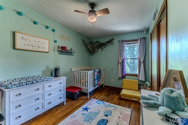 304 Warren St, Richland, MO 65556 - bedroom featuring dark wood-style flooring, a nursery area, and ceiling fan