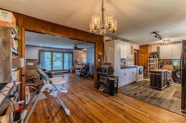 304 Warren St, Richland, MO 65556 - living area with dark wood-style flooring, a chandelier, ceiling fan, and washer / clothes dryer