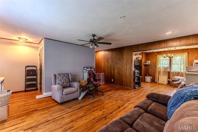 304 Warren St, Richland, MO 65556 - living area featuring radiator, wooden walls, wood finished floors, and a ceiling fan