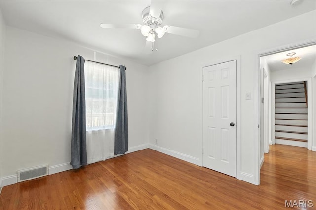 429 Belvedere Ln, Glendale, MO 63122 - unfurnished room with wood finished floors, a ceiling fan, and stairs