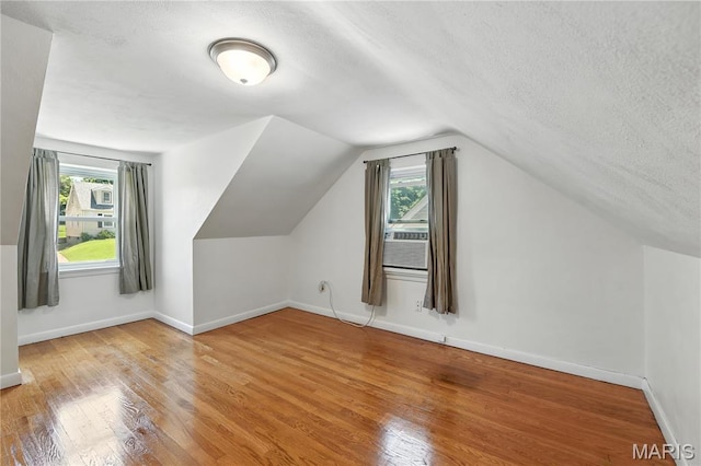 429 Belvedere Ln, Glendale, MO 63122 - additional living space with a textured ceiling, wood finished floors, plenty of natural light, and vaulted ceiling