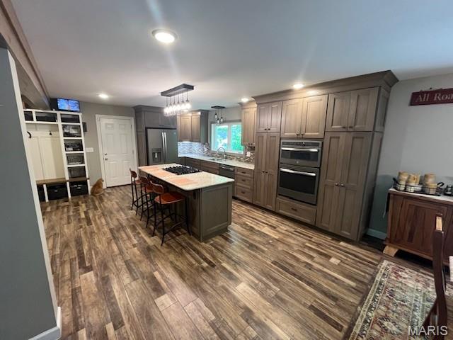 1333 Poor Farm Hollow Rd, Hardin, IL 62047 - kitchen with stainless steel appliances, dark wood-style flooring, light countertops, a kitchen breakfast bar, and pendant lighting