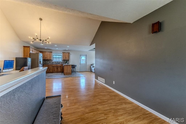 143 Lyle Curtis Cir, Waynesville, MO 65583 - unfurnished living room featuring light wood finished floors, a chandelier, and high vaulted ceiling
