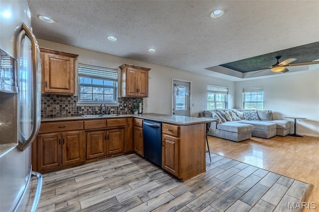 143 Lyle Curtis Cir, Waynesville, MO 65583 - kitchen with refrigerator, dishwashing machine, brown cabinetry, a peninsula, and light wood-type flooring