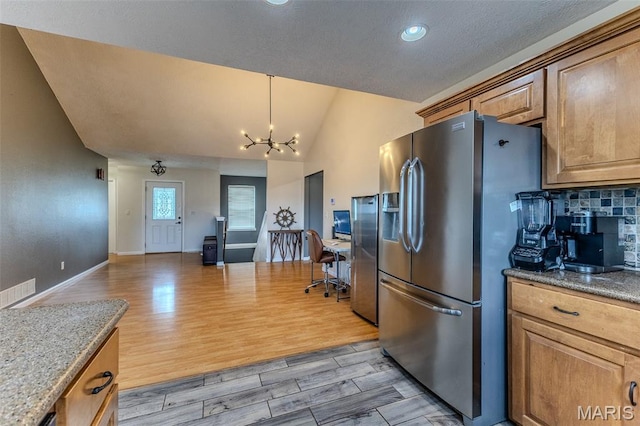 143 Lyle Curtis Cir, Waynesville, MO 65583 - kitchen with stainless steel fridge, vaulted ceiling, a chandelier, light wood-style floors, and brown cabinetry