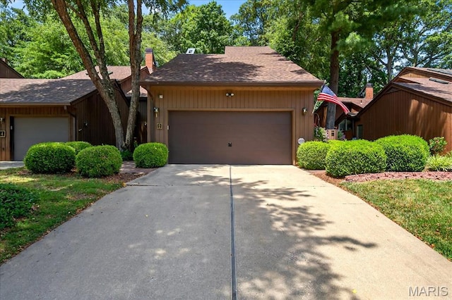 2 Tanewood Ct, Belleville, IL 62223 - view of front facade featuring a garage, driveway, a chimney, and a shingled roof